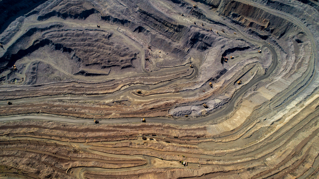 Aerial view of opencast mining quarry with lots of machinery at work.